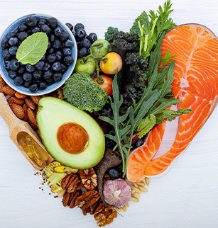 Bird’s eye view of healthy foods arranged in a heart on a white surface