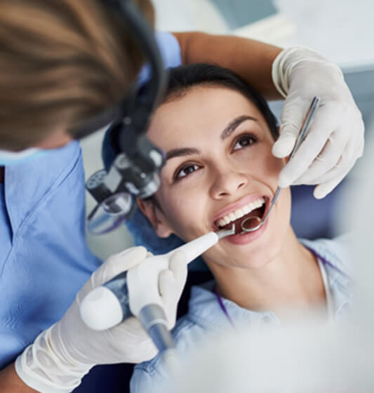 a woman having her teeth examined by a dentist