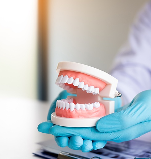 dentist holding dentures in hand 